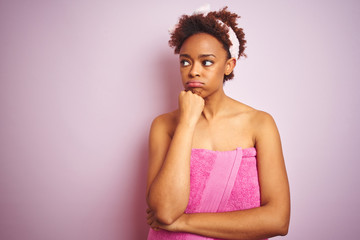 African american woman wearing shower towel after bath over pink isolated background thinking looking tired and bored with depression problems with crossed arms.