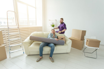 Two student male friends holding their things in their hands sitting in the living room of a new apartment. Housewarming concept