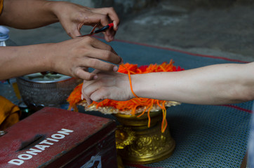 Hands tied to the sacred string, that Asia believed for good luck, happiness and good health.