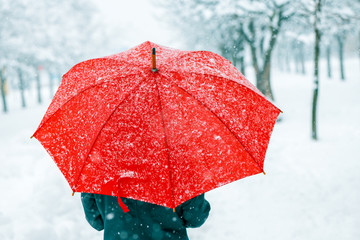 Woman with red umbrella in snow