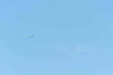 light green plane flies without leaving a trace on the background of the blue sky