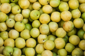 Background of fresh green plums on the market.