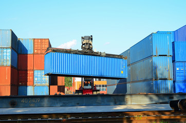 Shipping container loading by richtracker on the freight rail car at logistic warehouse port. Ocean...