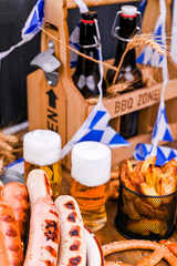 Fresh craft beer. German sausages on the grill. Traditional German sausages and pastry brezel for a beer festival. Wood background and decor.