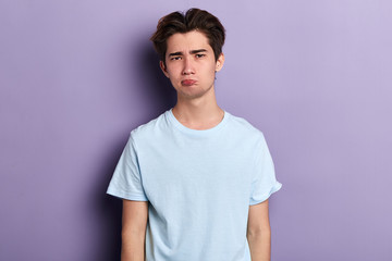 Obraz premium funny young man blowing cheeks, close up portrait, isolated blue background, close up portrait, studio shot. guy making faces