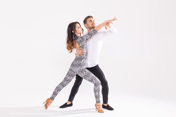 Young couple dancing latin dance bachata, merengue, salsa, kizomba. Two elegance pose over white background with copy space