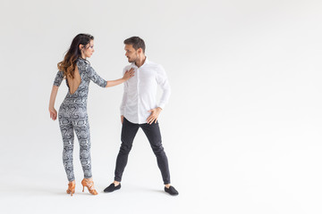 Social dance concept - Active happy adults dancing bachata together over white background with copy...