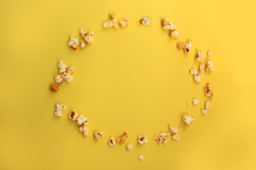 flavored popcorn scattered on an oval yellow background, copy space in the center