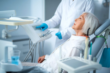 Adult woman with closed eyes in dental chair