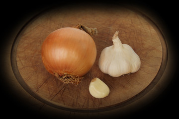 onion, garlic on a wooden round board, vegetables concept for health against colds, horizontal, closeup, copy space