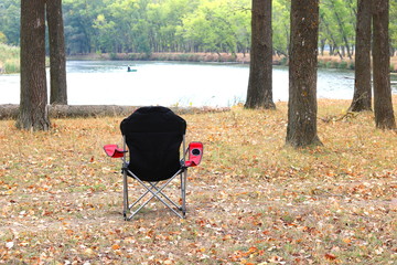 Tourist chair in autumn in park near the river