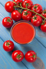 Fresh tomato juice as a source of vitamins. Wooden background.