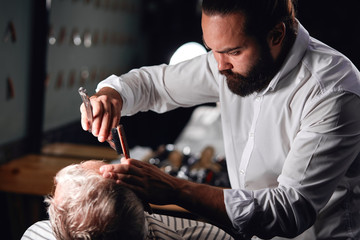 young man running a successful barbershop, close up croppped side view photo