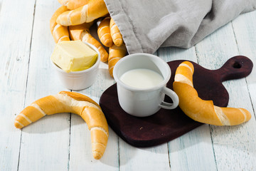 cup of milk and crescent rolls on white wooden © tstock