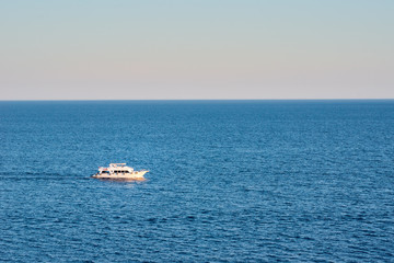 Fototapeta na wymiar White ship in sea or ocean against sunset