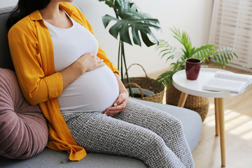 Cropped shot of young beautiful woman on third trimester of pregnancy. Close up of pregnant female...