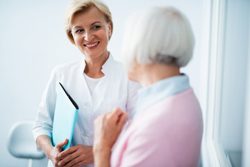 Obraz premium Happy dentist is looking at female patient