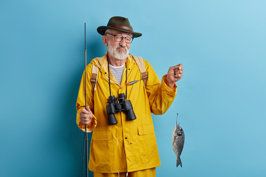 sad old granpa is bad at fishing, close up photo. isdolated blue background