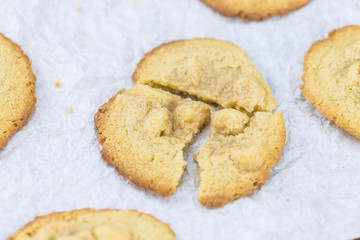 Old wooden table with fresh Macadamia Cookies (close-up shot; selective focus)