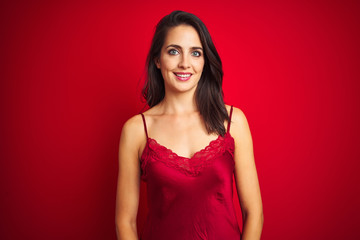 Fototapeta premium Young beautiful woman wearing sexy lingerie over red isolated background with a happy and cool smile on face. Lucky person.