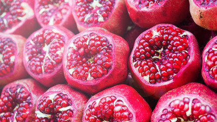 Background of fresh ripe pomegranates with incision on the counter in the street market.