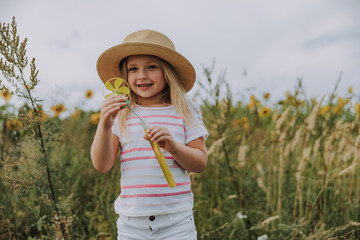 Caucasian smiling kid having rest near the field