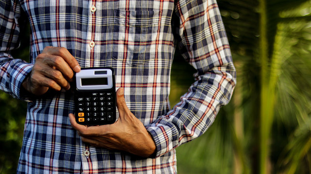 Calculator in the hands of a man on natural morning.