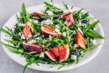 Arugula salad with figs, blueberries and goat cheese, balsamic sauce dressing