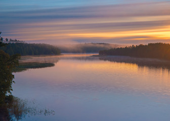 Long Exposure of Sunset at the Paijanne lake. Beautiful scape with sunrise sky, pine forest and water. Lake Paijanne, Finland.