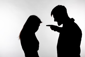Aggression and abuse concept - man and woman expressing domestic violence in studio silhouette...