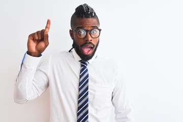 African american businessman with braids wearing tie glasses over isolated white background pointing finger up with successful idea. Exited and happy. Number one.