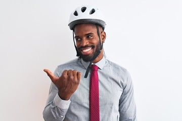 African american businessman with braids wearing bike helmet over isolated white background smiling with happy face looking and pointing to the side with thumb up.