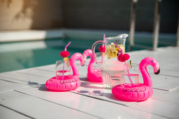 Cold drink with pink inflatable flamingo on the table