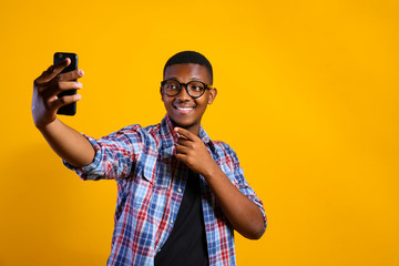 Young handsome man of african american ethnicity wearing checkered shirt posing over isolated background. Portrait of stylish confident male in casual outfit. Close up, copy space.