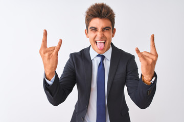 Young handsome businessman wearing suit standing over isolated white background shouting with crazy expression doing rock symbol with hands up. Music star. Heavy concept.