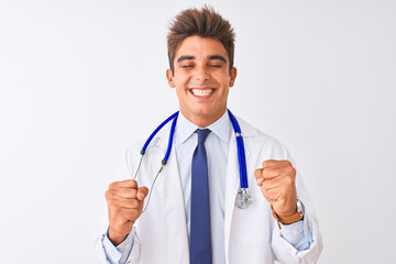 Young handsome doctor man wearing stethoscope over isolated white background excited for success with arms raised and eyes closed celebrating victory smiling. Winner concept.