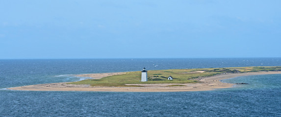 A lighthouse marks the end of a spit of land protruding out into the harbor at Provincetown,...