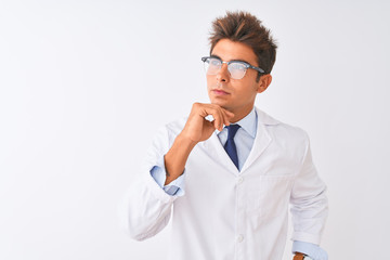 Young handsome sciencist man wearing glasses and coat over isolated white background with hand on...