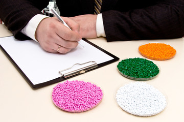 Businessman in the office signs a contract for the supply of plastic granules for industry. Plastic...