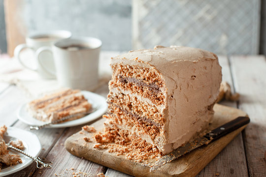 Homemade dacquoise cake with nuts and buttercream on wooden table