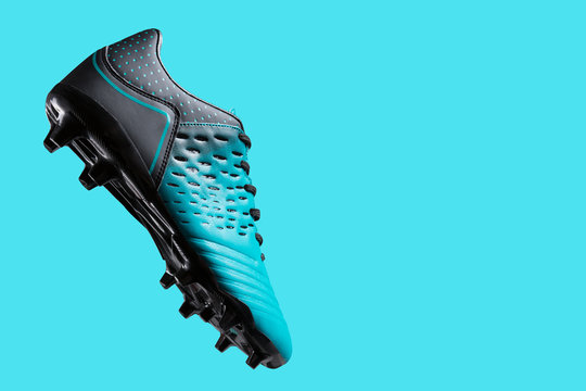 football boots hovering in the air, as if hitting the ball, concept, sports shoes, on a turquoise background