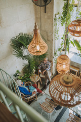 People sitting in the cafe with cane furniture design stock photo