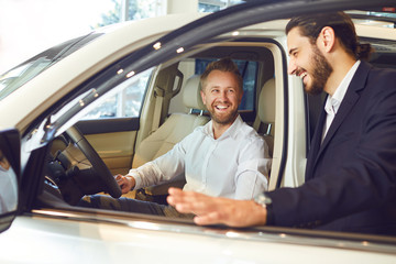 Car dealer showing automobile to client.