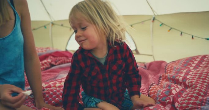 Toddler playing on bedding in tent