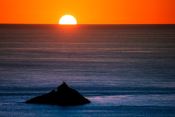 a rock against the sun touching the sea at capo sandalo in the Island of San Pietro, Sardinia - 289840687
