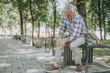 Aged man having sudden ache in his knee stock photo