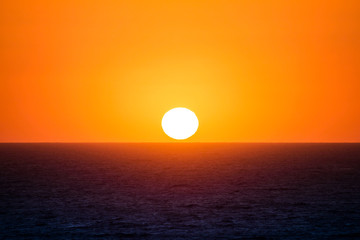 the sun is near the sea at capo sandalo in the Island of San Pietro, Sardinia