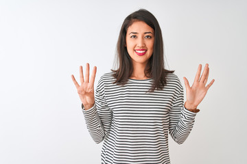 Young beautiful chinese woman wearing striped t-shirt standing over isolated white background...