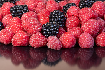 Ripe and fresh raspberries and blackberry, sweet dark blackberry over red raspberries, berries food