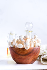 White buna-shimeji in wooden rustic bowl on white background